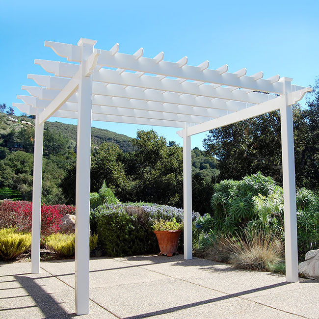 The Poolside Pergola framing a serene garden retreat. The UV-resistant white vinyl construction stands tall, perfect for creating a shaded lounge area or a relaxing poolside oasis in your backyard.